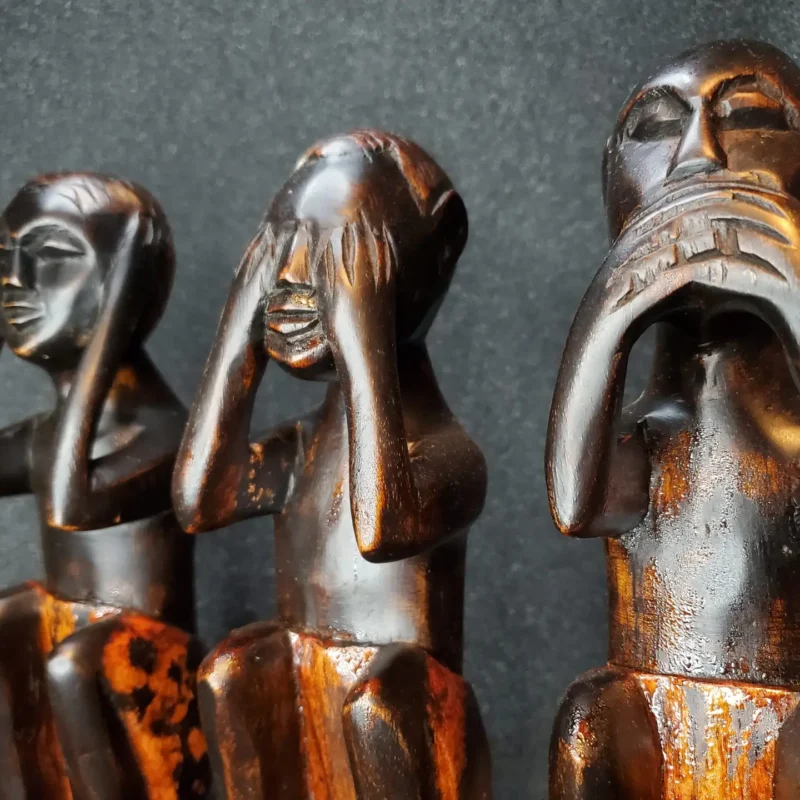 Set of three hand-carved Asante wooden figures in black finish from Ghana, depicting see-no-evil, hear-no-evil, speak-no-evil