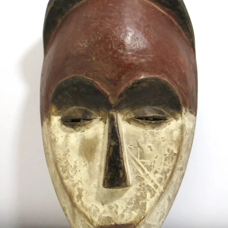 African tribal mask in red and white, hand-carved wooden mask